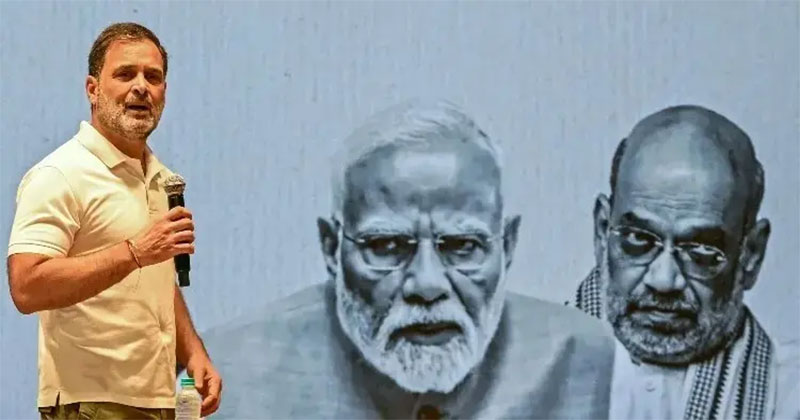 স্ক্রিনে মোদী ও অমিত শাহকে রেখে কথা বলছেন রাহুল গান্ধী/ ফাইল ছবি